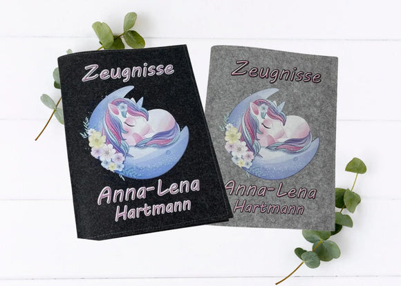 Personalisierte Zeugnismappen aus Filz mit schlafendem Einhorn auf Halbmond und Name in Hell- und Dunkelgrau.