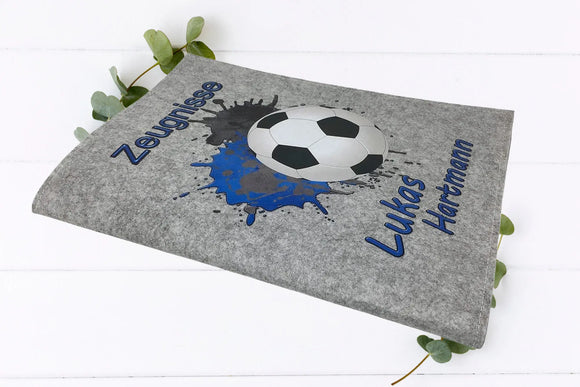 Sportliche Zeugnismappe mit Fußball und Farbexplosion – in Blau gehalten und mit Namensdruck.