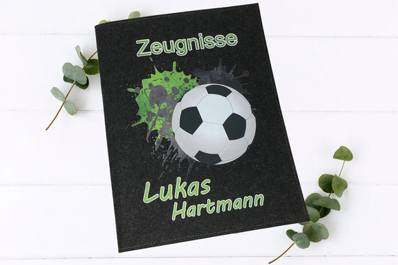 Filz-Zeugnismappen mit sportlichem Fußball-Design, grünem Splash-Hintergrund und individuellem Namensaufdruck.