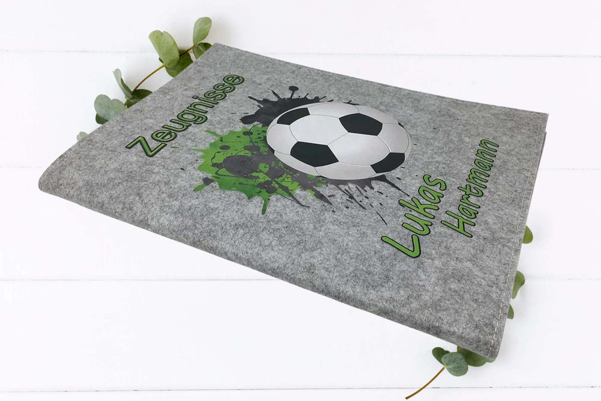 Kinder-Zeugnismappe mit Fußball, Farbspritzern in Grün und Wunschname auf Filz – in zwei Farben erhältlich.