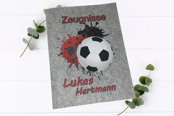 Zeugnismappe für Fußballfans – Ball-Motiv mit Farbspritzern und Wunschname auf robuster Filzhülle.