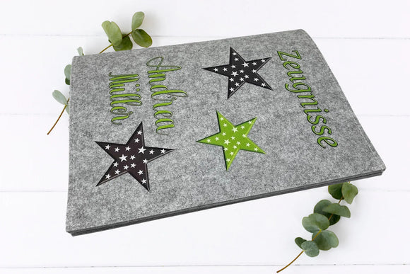 Zeugnismappen mit modernen Sternmotiven, Namensaufdruck und grün-schwarz-grauem Design – auf Filz.