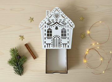 Geschenkschachtel Hausform aus Holz mit filigranen Lasercut-Details auf hellem Hintergrund