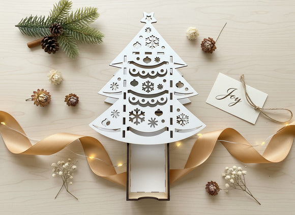 Geschenkschachtel Tannenbaum aus Holz mit filigranem Laserschnitt auf hellem Hintergrund
