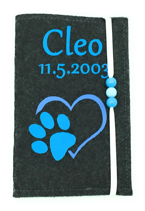 Schwarze Filz-Impfpasshülle mit blauem Aufdruck und weißem Gummiband.