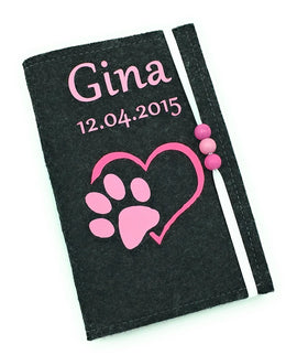Filzhülle für Heimtierausweis mit pinkem Pfotenmotiv und Herzform auf schwarzem Hintergrund.