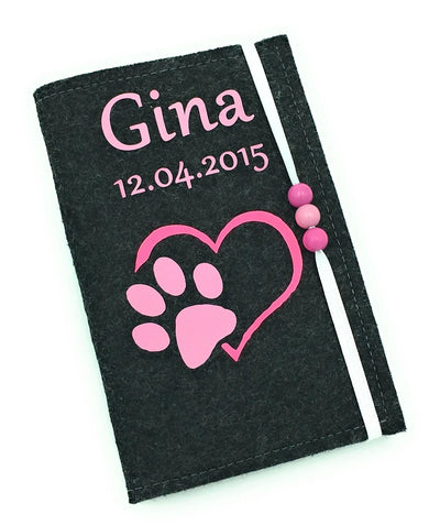 Filzhülle für Heimtierausweis mit pinkem Pfotenmotiv und Herzform auf schwarzem Hintergrund.