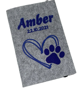 Hellgraue Filzhülle für Heimtierausweis mit dunkelblauem Herz- und Pfotenmotiv.