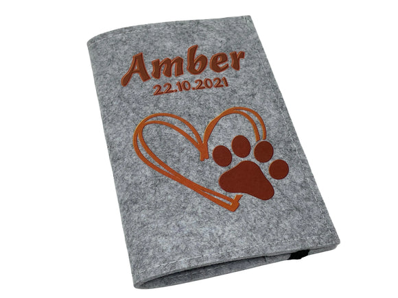 Tierausweishülle in hellgrau mit Pfotenabdruck und Herzmotiv in warmem Braunton.