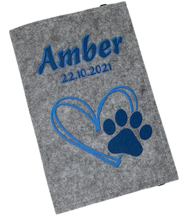 Hellgraue Filzhülle für Heimtierausweis mit Herz- und Pfotendesign in Hellblau.