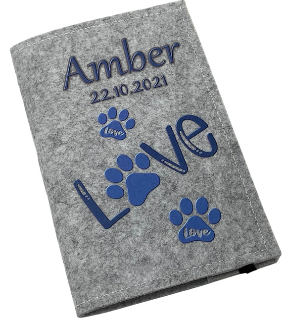 Hellgraue Filzhülle für Heimtierausweis mit blauem „Love“-Schriftzug und Pfotenabdrücken.