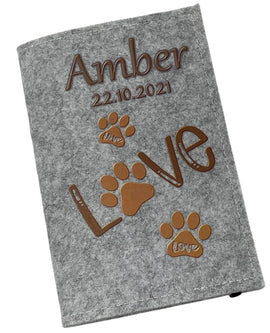 Hellgraue Filzhülle für Heimtierausweis mit braunen Pfotenabdrücken und „Love“-Schriftzug.