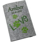 Hellgraue Filzhülle für Heimtierausweis mit grünem „Love“-Schriftzug und Pfotenspuren.