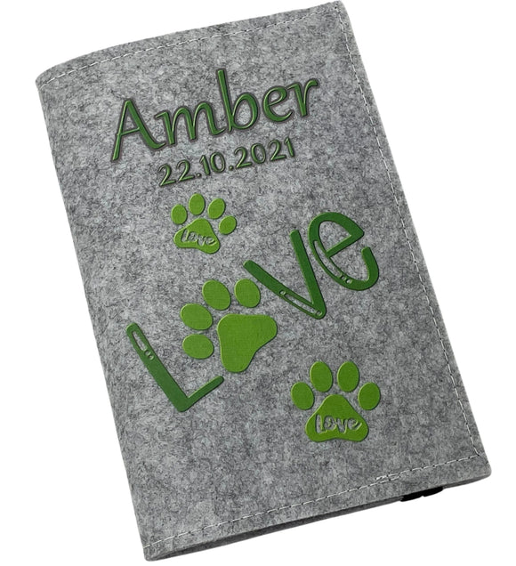 Hellgraue Filzhülle für Heimtierausweis mit grünem „Love“-Schriftzug und Pfotenspuren.