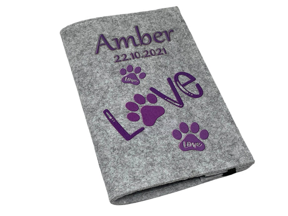 Tierausweishülle mit lila Designelementen auf hellgrauem Filz – dekorativ und funktional.