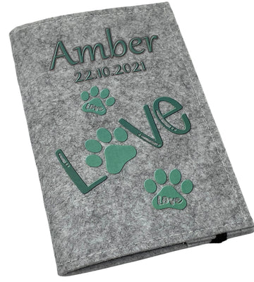 Hellgraue Filzhülle für Heimtierausweis mit mintgrünem „Love“-Schriftzug und Pfotenabdrücken.