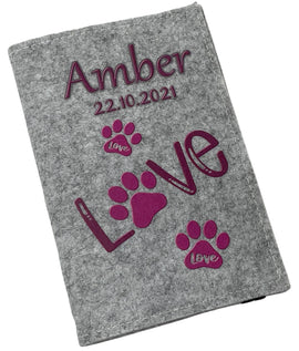 Hellgraue Filzhülle für Heimtierausweis mit pinken Pfotenabdrücken und dem Wort „Love“.