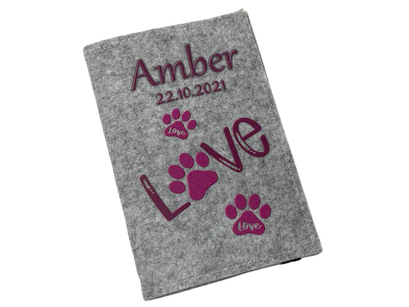 Liebevoll gestaltete Hülle für Heimtierausweis mit verspielten Pfotenabdrücken in Pink.