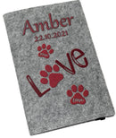 Filzhülle für Heimtierausweis in Hellgrau mit rotem „Love“-Schriftzug und Pfotenabdrücken.