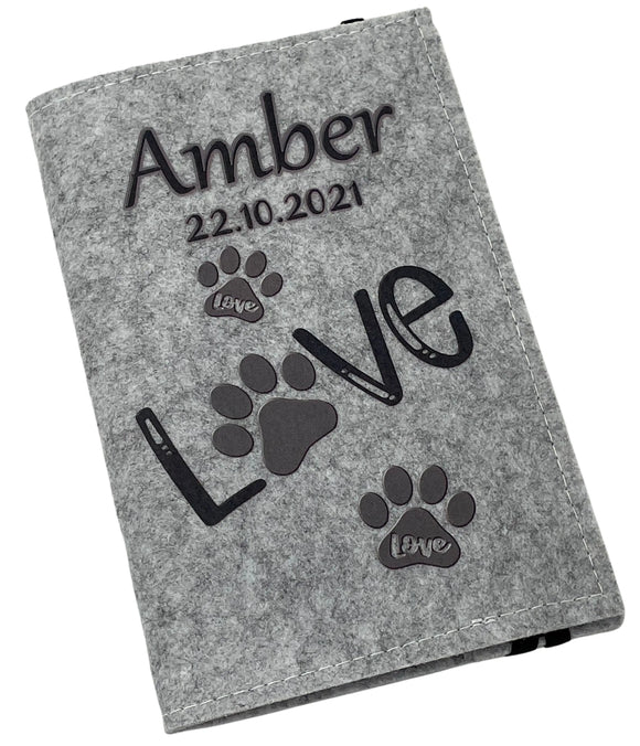 Hellgraue Filzhülle für Heimtierausweis mit schwarzem „Love“-Schriftzug und Pfotenabdrücken.