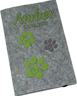 Personalisierte Impfpasshülle aus Filz mit Namen und grünen Pfotenabdrücken.