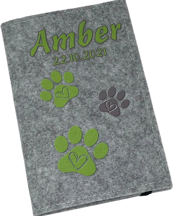 Personalisierte Impfpasshülle aus Filz mit Namen und grünen Pfotenabdrücken.