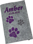 Graue Filzhülle für Heimtierausweis mit Namen und Pfotenmotiv in Lila.
