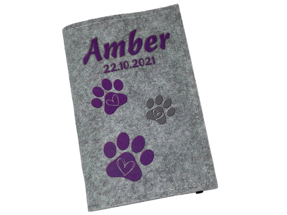 Tierausweishülle aus Filz mit Aufdruck: Name, Datum und drei Pfotenabdrücken.