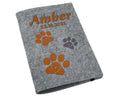Heimtierausweishülle aus grauem Filz mit orangem Design und Herzpfoten.