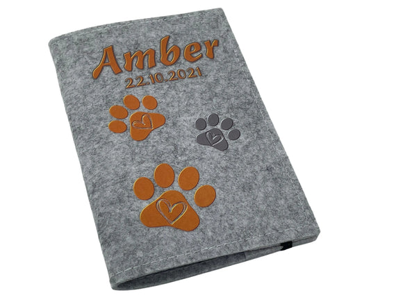 Heimtierausweishülle aus grauem Filz mit orangem Design und Herzpfoten.