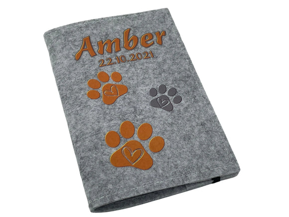 Warmes Orange für treue Begleiter – personalisierte Impfpasshülle mit Herzpfötchen.