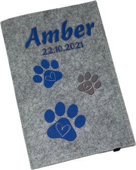 Personalisierte Filzhülle für Heimtierausweis mit blauen Pfoten.