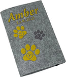 Personalisierte Filzhülle für Heimtierausweis mit Namen, Datum und gelben Pfotenabdrücken.