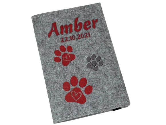 Filzhülle mit Wunschname und Datum – rotes Pfötchendesign mit Herz.