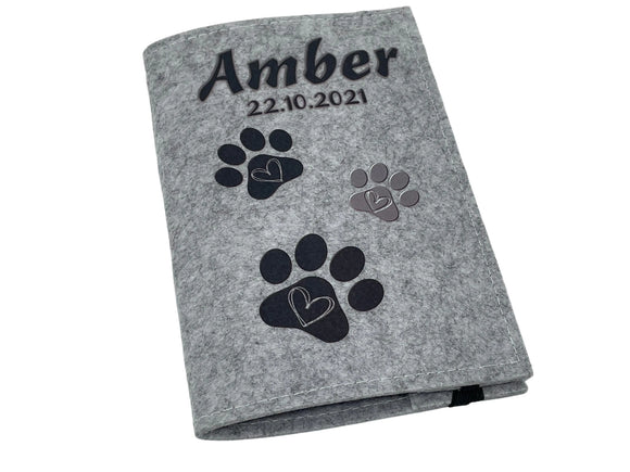 Personalisierte Impfpasshülle für Hund oder Katze – schwarzes Pfötchendesign mit Herz.