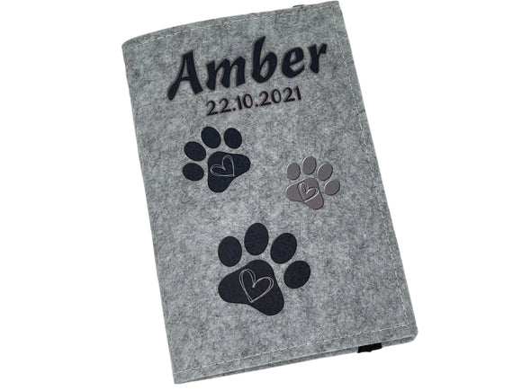 Filzhülle für EU-Heimtierausweis mit Name, Datum und drei Tatzen in Schwarz und Grau.